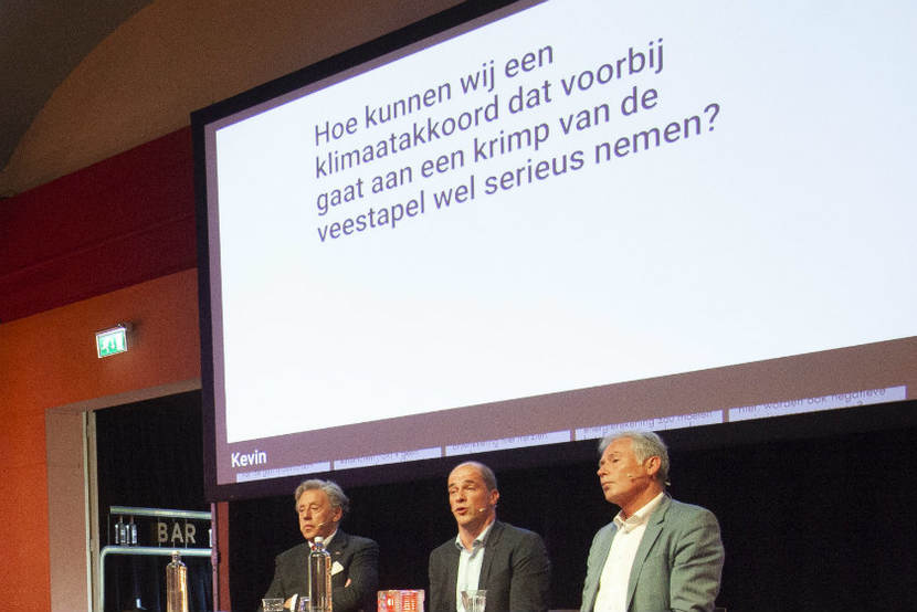 Publieksvraag op beeldscherm geprojecteerd achter de sprekers Ed Nijpels, Diederik Samsom en Pim van den Berg